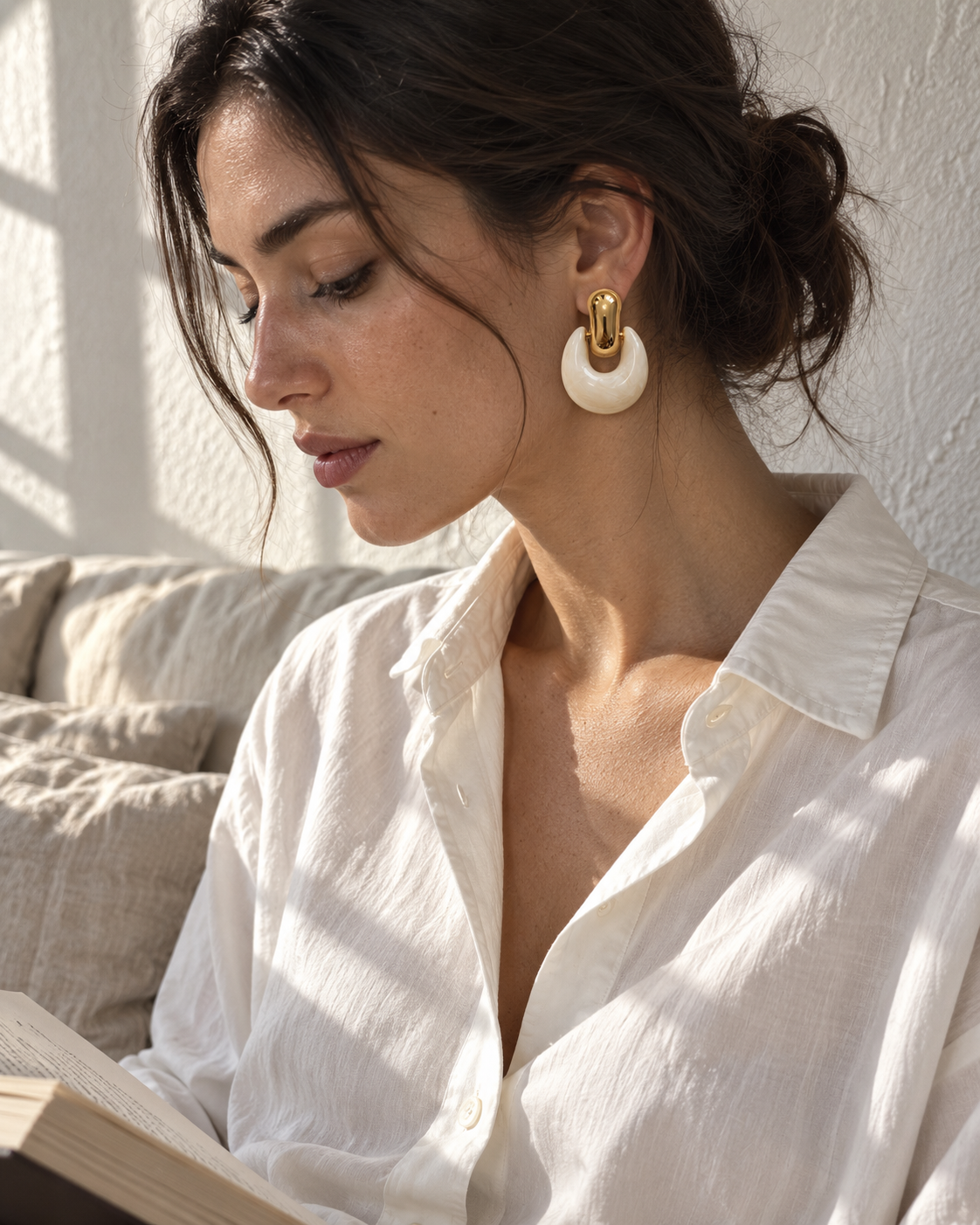 Lune krem sallantılı küpe, pencere ışığında beyaz gömlekle model üzerinde editöryal styling.